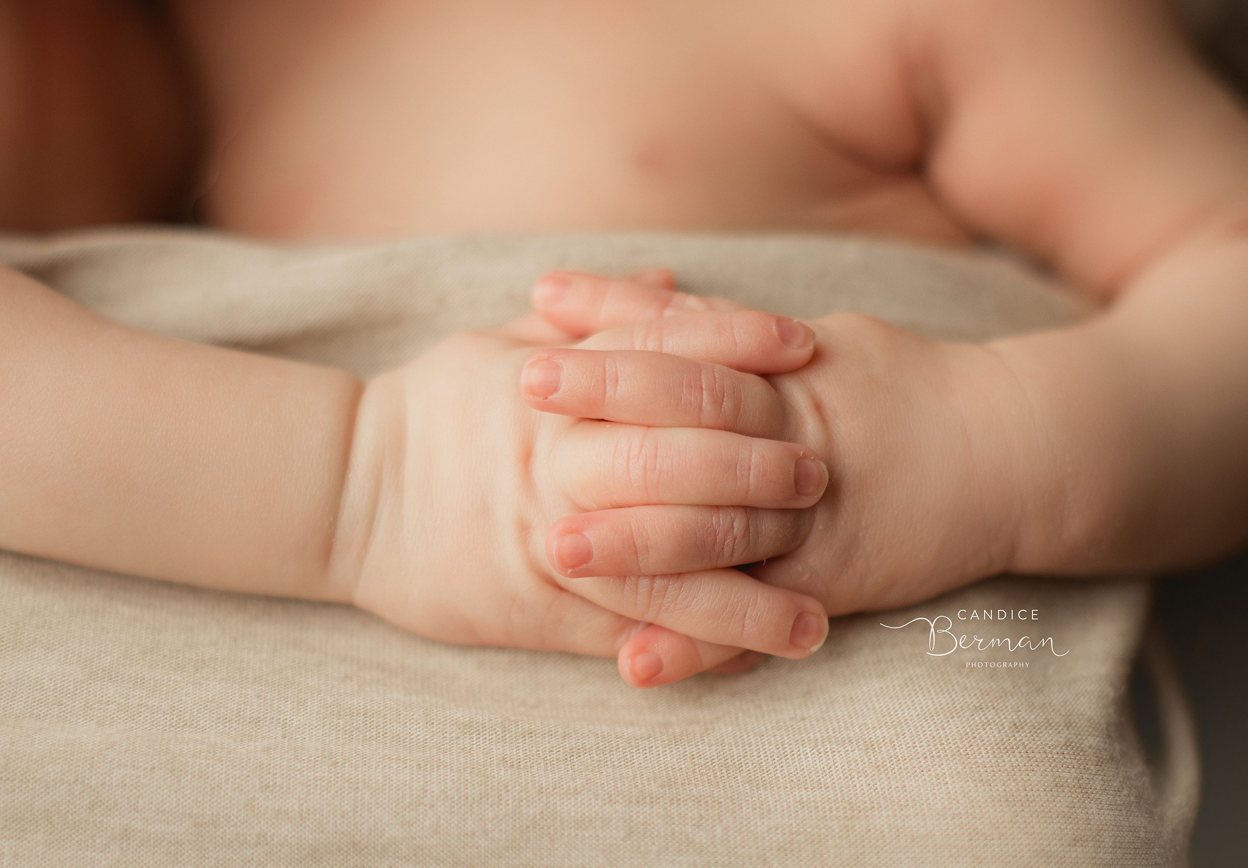 Details of a newborn baby's hands folded into each other thanks to postpartum doula orange county